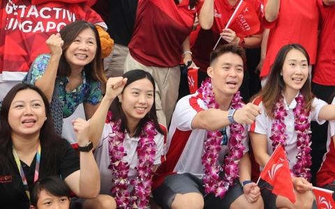 我国羽将杨佳敏（中）与队友许永凯（右二）和陈薇涵（右一）出席游行活动，杨佳敏母亲王芳贵（左二）也到场支持。（唐家鸿摄）