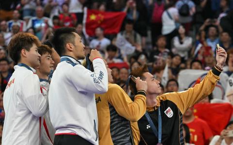 中华台北球员李洋（中）在自拍合照时，对掌镜的马来西亚球员苏伟译（右一）说：“要拍好哦，我只剩这一场可以拍咯！”（法新社）