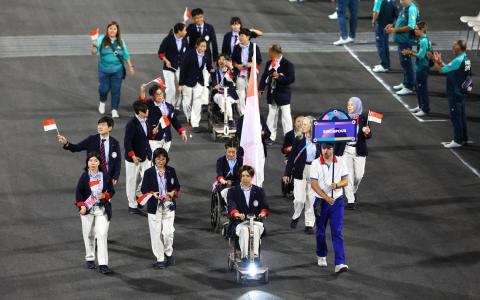 新加坡团队在巴黎残奥开幕式上，在擎旗手杜维崧（前排右二）率领下步入场中。（路透社）
