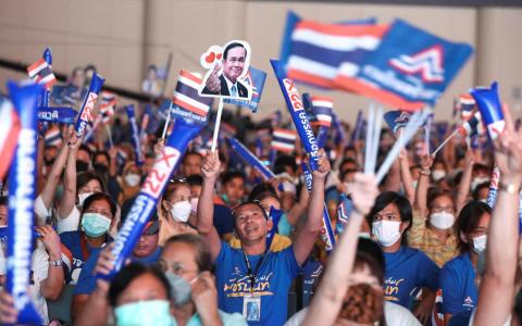 泰国人团结建国党和看守首相巴育的支持者星期五参加选前最后一场竞选集会，高举党旗和巴育头像呐喊。泰国选举法规定，所有拉票活动必须在星期六傍晚6时结束，所以各党星期五卯足全力，尽最后一分钟的努力。（路透社）