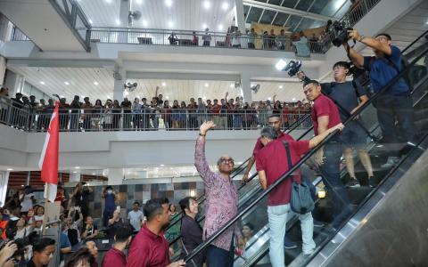 反对党人希望在同一阵线为陈钦亮壮大声势，结果适得其反，令本来可能有意对体制投反对票的中间选民更谨慎和务实地投票，把票投给更熟悉、更有亲和力的尚达曼（举手者）。（何炳耀摄）