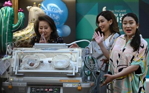 泰国最大反对党为泰党首相人选佩通坦（右）在家人的陪同下，星期三在曼谷一家医院向媒体介绍其新生儿布达信。（法新社）