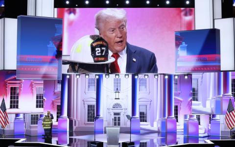 美国前总统特朗普7月18日在在威斯康星州密尔沃基举行的共和党全国代表大会第四天集会上发表演说，还触碰在他险遭暗杀的集会上遇难的消防员的制服。（路透社）