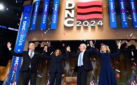 8月22日，在芝加哥举行的民主党全国代表大会最后一天集会上，美国副总统哈里斯（左二）和丈夫埃姆霍夫（左一），以及哈里斯的竞选搭档明尼苏达州长沃尔兹（右二）和夫人格温（右一）牵手亮相。（法新社）