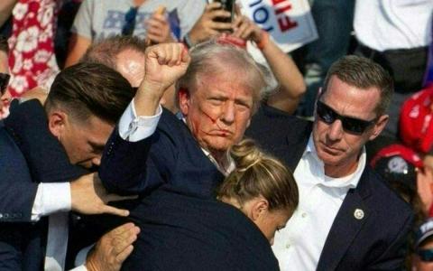 特勤局人员准备护送他离开讲台时，特朗普对台下振臂握拳，高喊三声“战斗”！（法新社）