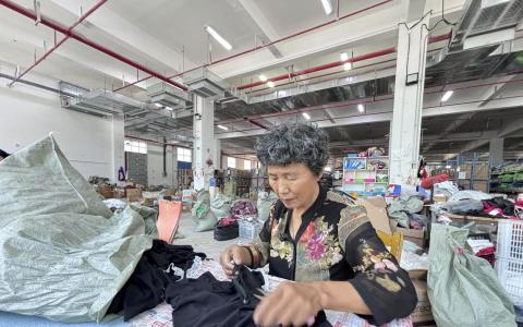 江苏灌云午夜魅力制衣厂质检工冯明霞（67岁），9月2日在厂里检查制作好的情趣内衣。（黎康摄）