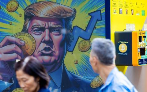 12月5日，美国当选总统特朗普在香港一家店面的宣传海报中拿着比特币的卡通形象。（彭博社）