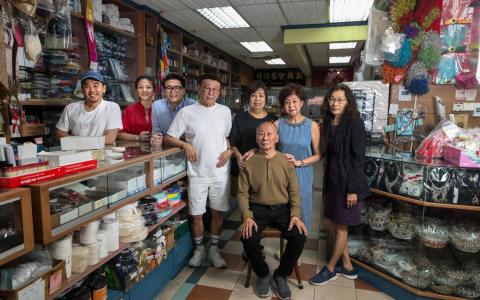 新兴泉记从起初在克莱街的小店铺，到如今桥北路和布业中心的两家店面，饱含一家人的心血。第二代最年长的黄昭国（前排）与他背后的妻子谢绣琴（后排右二）、大姐黄玉兰（后排右起）、四妹黄玉芳和二哥黄昭宝，还有第三代长孙黄泉铵与妻子黄如意，以及弟弟黄健安，几乎每天都在一起共事，朝夕相处。（白艳琳摄）