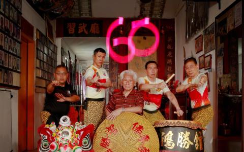 阵阵铿锵的锣鼓声划破芽笼15巷宁静的早晨，鸿胜馆的弟子扎稳马步练拳脚、耍刀枪、舞狮头，个个英姿飒爽。年近九旬的掌门人谢炎顺（中）依旧聚精会神提点示范，将多年苦习的技艺倾囊相授，盼徒弟匡世昌（左一）、汤联裕（左四）、潘景开（左五）和徒孙杨子为（左二）延续这份珍贵的文化遗产。（白艳琳摄）