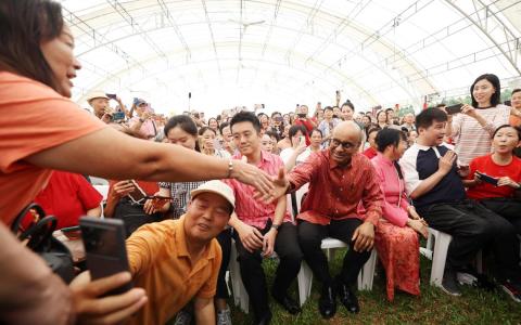 尚达曼总统（坐者右四）伉俪，出席星期天（2月2日）的总统府新春开放日，与公众一起欣赏舞台的精彩表演。总统也同现场热情观众握手致意。（郑一鸣摄）