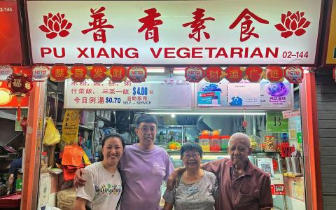 20多年来，郑智光（左二）全家都得提早吃团圆饭，因为从大年除夕到十五，全家都会总动员，亲手准备食材开档。（郭跃男摄）