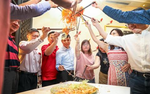 人日前的大年初六，食客们在位于马真路的同乐海鲜餐馆捞鱼生。 （刘欣怡摄）