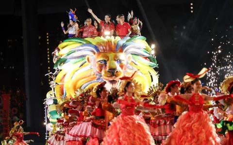 黄循财总理（中）与文化、社区及青年部长兼律政部第二部长唐振辉（左二），以及人民协会总执行理事长卓荣能（右二）一同乘坐SG60妆艺雄狮花车入场。（关俊威摄）