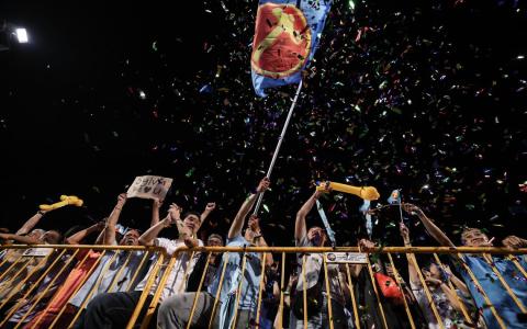 在实龙岗体育场等待选举成绩的支持者挥舞工人党党旗。（关俊威摄）