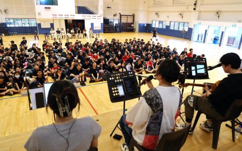 “新空下”2025年音乐分享会正在如火如荼进行中，图为弹唱人制作室团队走入军港中学，与学生近距离接触。（萧紫薇摄）