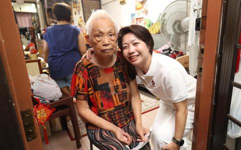 出战蒙巴登单选区的人民行动党新人吴诗琪（右）欢迎竞争，希望赢得选民的委托。她星期五晚上走访惹兰峇株组屋区，上门问候居民。（郑一鸣摄）