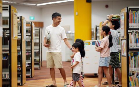 行动党惹兰勿刹集选区候选人罗守恩（左一）在冷静日带着孩子们前往芽笼东图书馆借阅书籍。每两周去一次图书馆，是罗守恩一家长久以来的习惯。（谢智扬摄）