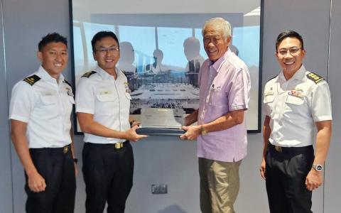 卸下国防部长职务的黄永宏医生（右二）星期五在脸书上发文，分享海军总长屈坚文少将（左二）代表海军向他赠送纪念牌。（取自黄永宏医生脸书）