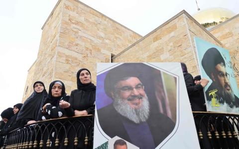 10月14日，黎巴嫩比布鲁斯市（Byblos）附近一个村子的村民为在以色列空袭中丧生的遇难者举行葬礼，摆出真主党领导人纳斯鲁拉的肖像。9月27日，纳斯鲁拉在以军空袭中身亡。（法新社）