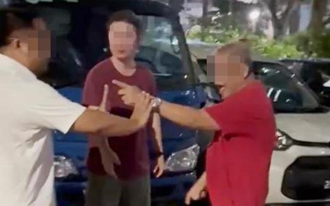 一名红衣男子（右）5月3日晚上涉嫌破坏张挂在后港5道第328座组屋附近的人民行动党旗帜，并把停在露天停车场竞选车上的政党海报撕下。 （读者提供）