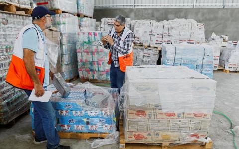 10月23日，红新月会工作人员在加沙南部清点人道主义援助物资，分发给加沙的巴勒斯坦居民。（路透社）