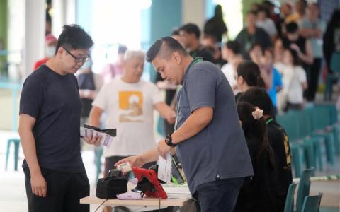 选举局说，投票正顺利进行，全岛的1264个投票站中，只有一些投票站排起了较短的队伍。（谢智扬摄）
