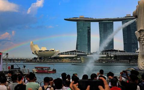 国庆庆典开始前，滨海湾一度飘下细雨，暑气稍减，更在天际画出一道绚丽彩虹。人们纷纷掏出手机，录下这个令人愉悦的惊喜。（陈心媛摄）