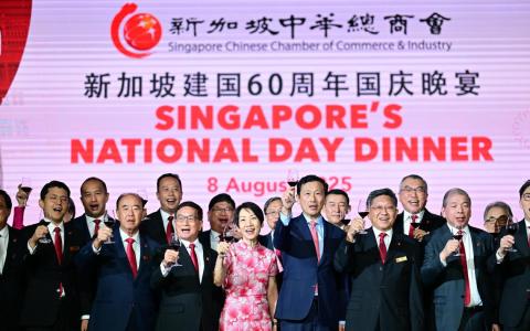 新加坡中华总商会2025年国庆晚宴上，卫生部长兼社会政策统筹部长王乙康（前排右四）、永续发展与环境部长傅海燕（前排右五）、新加坡中华总商会会长高泉庆（前排右三）、新加坡中华总商会前任会长黄山忠（前排左四）以及商会代表等，与出席者共同欢庆新加坡建国60周年。（新加坡中华总商会提供）
