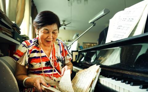 在陈毓申家中，随处可见泛黄的歌本，里头收录着一首首她和学生唱过的歌。每次找歌谱，她总能信手拈来。（邝启聪摄）