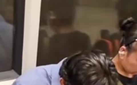 身穿西装衬衫的男乘客罔顾众人眼光，在地铁内肆无忌惮地吃着熟食。（视频截图）