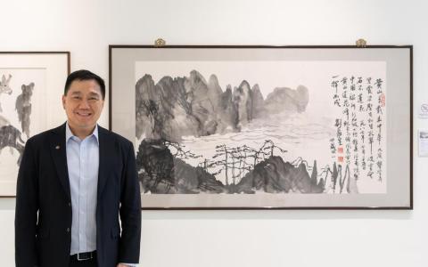 中国银行新加坡分行副行长陈金来与中国艺术家刘海粟黄山水墨画（1987）合影。（中国银行新加坡分行提供）