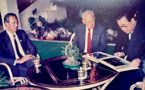 图为1990年，李光耀总理（中）结束北京的访问，中国总理李鹏前来钓鱼台国宾馆送行，并将新加坡代表团在北京活动的相簿送给李总理，左为副总理吴作栋。（档案照片）