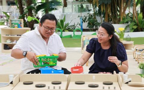 1岁半阿乌菲的父亲阿兹尔（Azirwan bin Mastan，左）和母亲努迪雅娜（Nurdiana Binte Abdul Rahim，右）让儿子加入“任务我行2”计划，在量身制定的训练下，他的发育逐步回到正轨。（唐家鸿摄）
