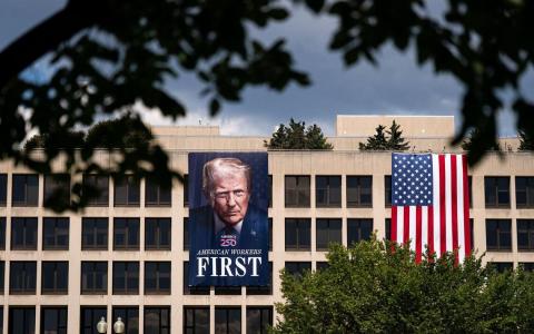 特朗普的关税政策影响很可能延续至其个人任期之外，并在一定时期内深刻塑造国际经济秩序。图为美国劳工部外挂起特朗普的画像。（彭博社）