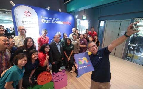 同是人协副主席的律政部长兼内政部第二部长唐振辉（右一）星期六（11月8日）为展览主持推介。配合展馆，人协也出版《我们的社区》纪念书，介绍人协职员、基层领袖和义工，通过他们的故事，展现志愿服务精神。（李冠卫摄）