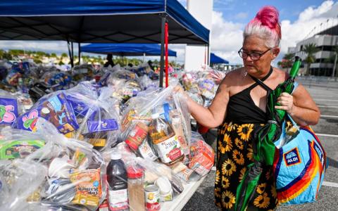 11月9日，佛罗里达州一处为补充营养援助计划 (SNAP) 受益人举办的免费食品分发活动中，一名妇女领取了一袋食品杂货。美国最高法院11月7日裁定，特朗普政府无须立即支付因政府停摆而被削减的SNAP食品福利金，这项临时命令使数百万人的生活陷入困境。（法新社）