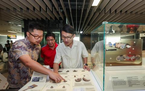 交通部兼文化、社区及青年部政务部长马炎庆（右起）、SMRT集团首席乘客体验与服务质量官揭育文，以及国家文物局文化遗产政策和研究副经理沈冠雄一同近距离观看展品。（白艳琳摄）
