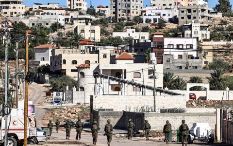 11月26日，执行军事行动的以色列士兵在约旦河西岸图巴斯的街道上巡逻。（法新社）