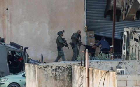 巴勒斯坦通讯社报道，以军包围一处建筑，用推土机破坏大门，迫使建筑内两名巴勒斯坦青年走到室外，随后射杀两人。（路透社）