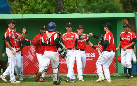 我国棒球队拿下第二胜后，将在星期二（9日）挑战东道主泰国。图为我国球员在对垒老挝得分时，兴奋庆祝。（新加坡体育理事会提供档案照）
