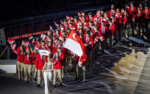 出席开幕式的我国代表团共有112人，羽毛球“一姐”杨佳敏（举旗者）和巴西柔术选手林天润（杨佳敏右边，镜头被挡）是擎旗手。（白艳琳摄）