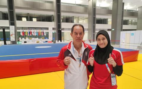 卡蒂嘉（右）成功锁定武术散打奖牌后，和我国散打主教练黄文福合照。（陈明耀摄）