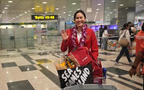 载誉而归的我国资深泳将柯婷文围着胡姬花花环，向前来接机的支持者挥手致意。回国后，她还想找些榴梿来吃，好好犒劳自己。（谢智扬摄）