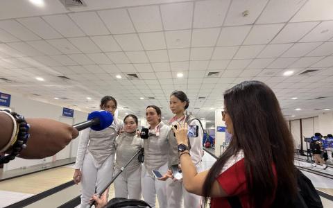 击剑比赛结束后，新加坡队新闻官（右一）安排我国女子花剑队李亭仪（左起）、黄颉歆、阿米塔和章可美接受媒体采访。（陈芷馨摄）