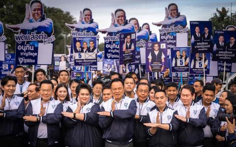 泰国首相及泰自豪党党魁阿努廷（中）星期天带领党员完成政党议席候选人登记工作后，比出日本超人奥特曼发射能量的经典手势，暗指将横扫竞争对手。（法新社）
