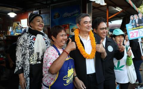 泰国前首相及民主党党魁阿比昔（中），星期天（1月4日）带领民主党候选人在曼谷走访选民拉票，获得不少选民热情回应。（取自泰国民主党脸书）