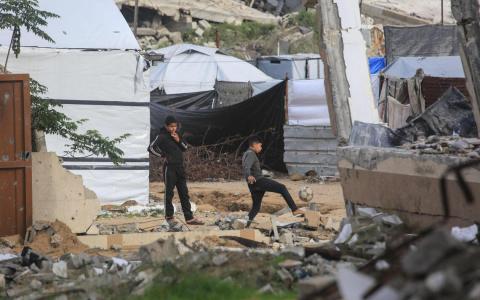 1月10日在加沙北部贾巴利亚地区，当地巴勒斯坦儿童在受战火破坏的建筑物中玩耍。（法新社）