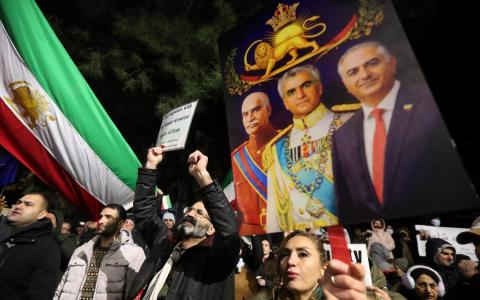 伊朗国内长期积累的问题，以及政教合一野蛮落后统治的穷途末路，在2025年底骤然突破临界点。图为1月14日，中亚国家格鲁吉亚首都的伊朗大使馆外，人们高举前王室成员的图片，支持伊朗国内的示威者。（路透社）