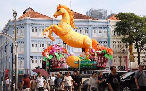 距离丙午马年不到一个月，一匹8.8米高的金黄色骏马一夜间“跃”入牛车水，为路人带来新年气息。（萧紫薇摄）