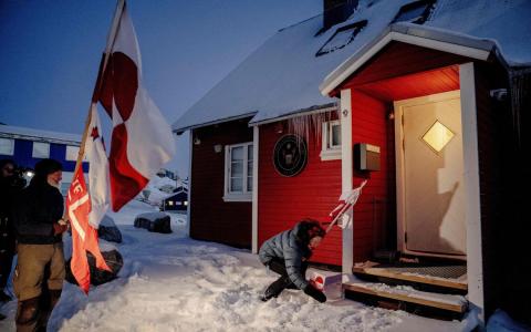 1月20日，抗议者在格陵兰首府努克的美国领事馆外举着旗帜示威。（法新社）